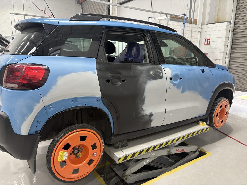 Blue Citroen C3 in the workshop showing filler and restoration in progress.